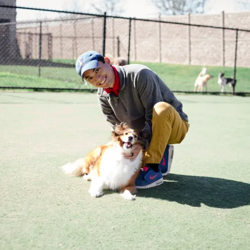 Employee holding dog at dog daycare Elite Suites Heath